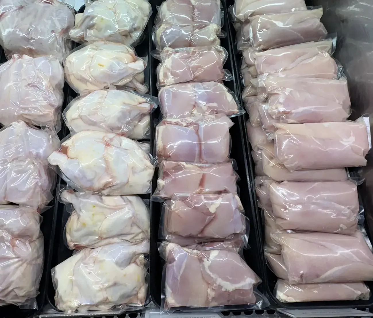 Rows of fresh chicken in sealed bags in the Plymouth Prime Meats case